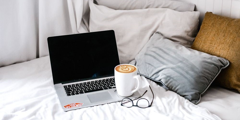 Bild zum Blogbeitrag "Schreibtipps für deinen Blog", Bild zeigt einen Laptop und Kaffeetasse auf einem Sofa