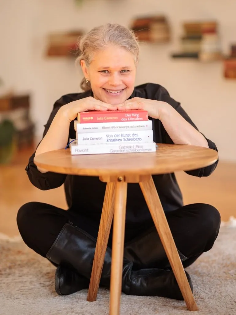 Christine Kämmer in lockerer Haltung mit Schreibratgebern.